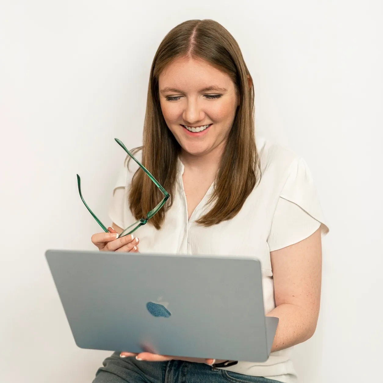 girl in hat sitting on bench with laptop