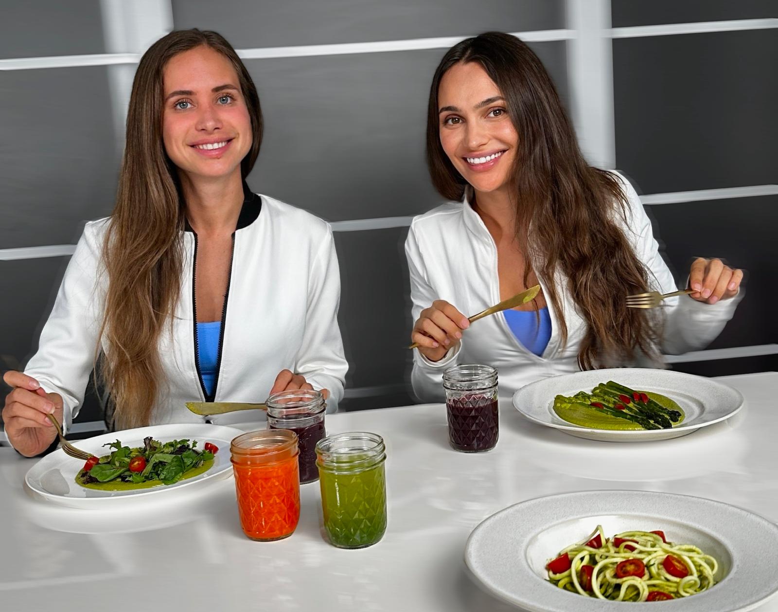 Natalie and Irina, founders of The Healthiest Chef, enjoying colorful plant-based dishes and fresh juices together