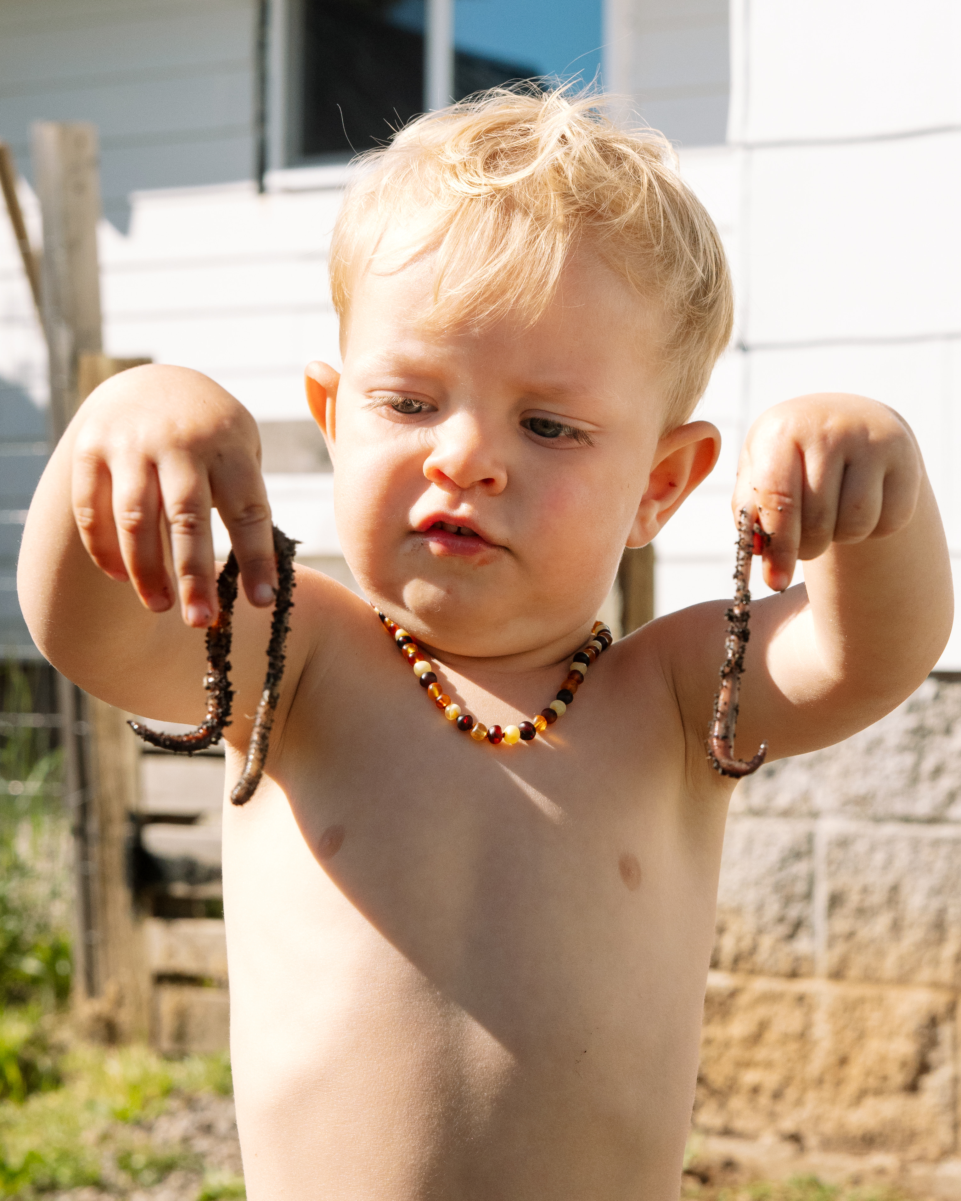 Levi outside holding up worms in both hands