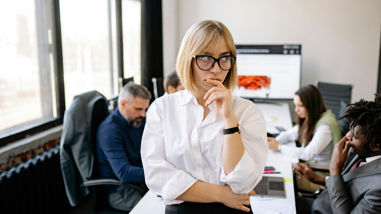 A woman with a pensive look with people in the background