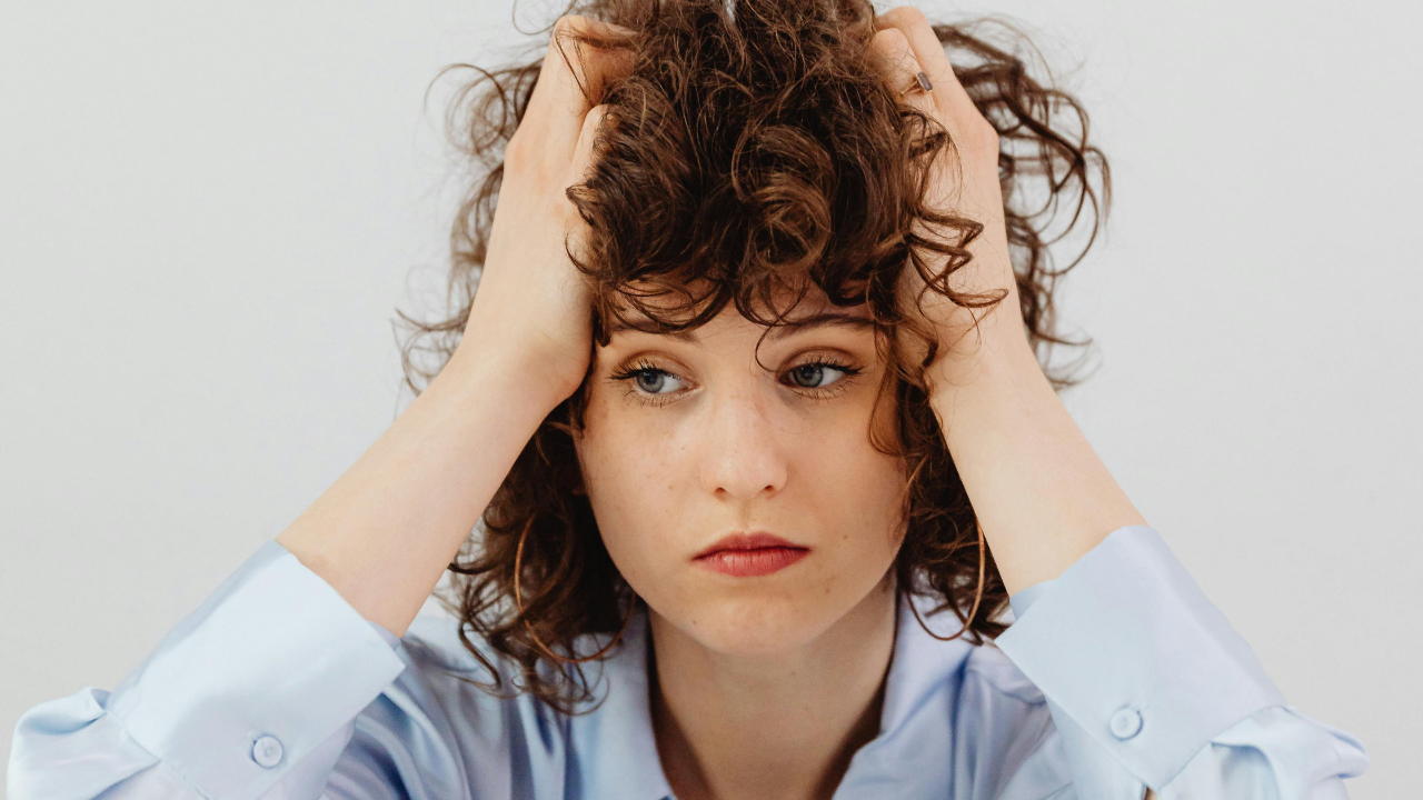 A woman grabbing her hair looking stressed