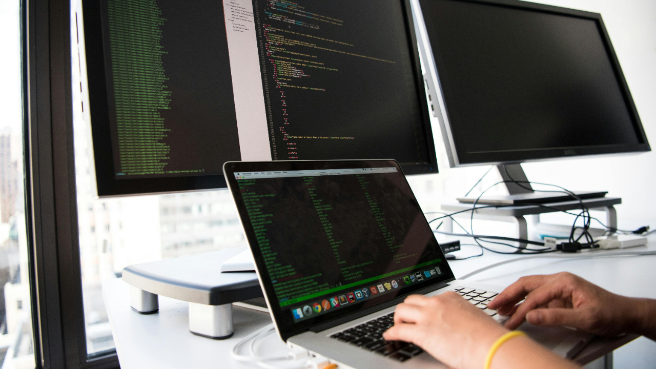 Someone programming on multiple computer monitors