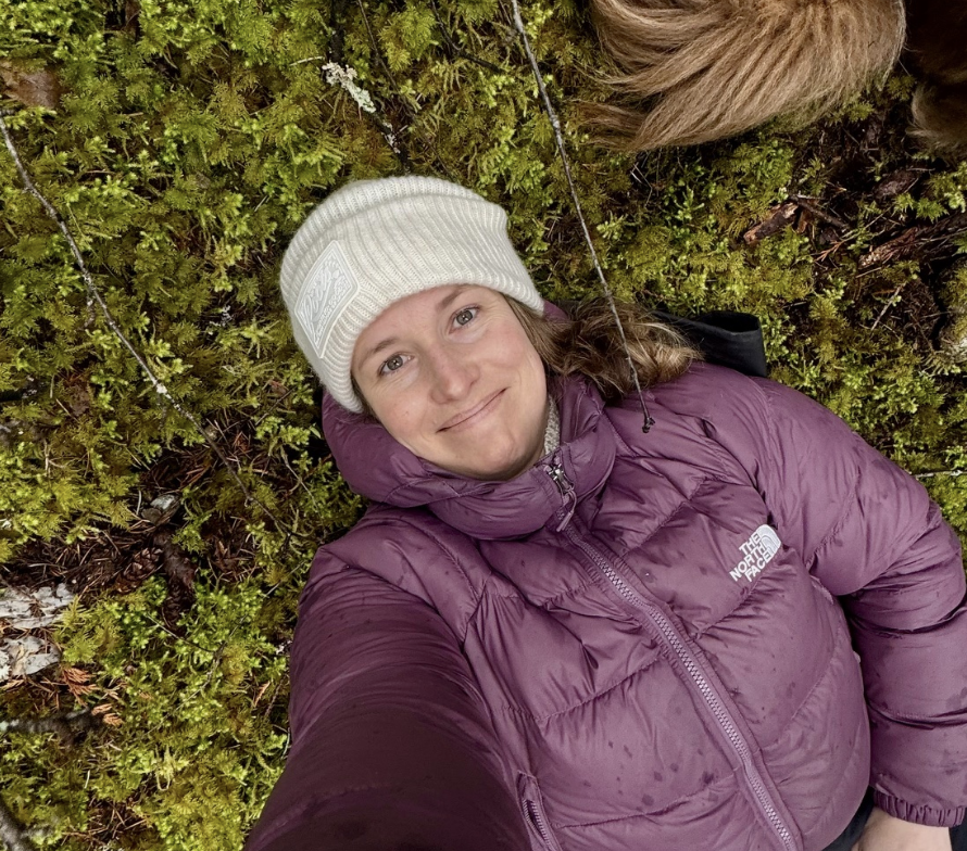 A young woman lying in the grass, resting after an emotionally intense therapy session in a moment of quiet reflection and release.