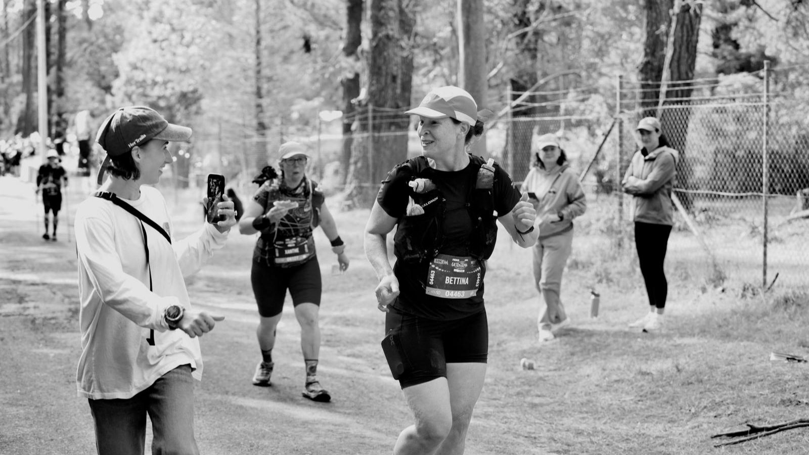 Female trail runner on an easy base run through forest, building aerobic foundation for ultramarathon training