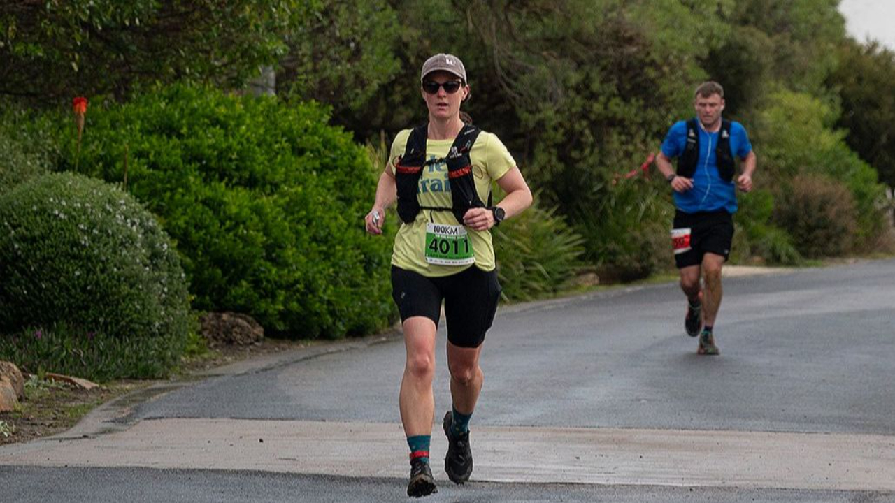 Female trail runner racing on steep terrain — Her Trails Coaching