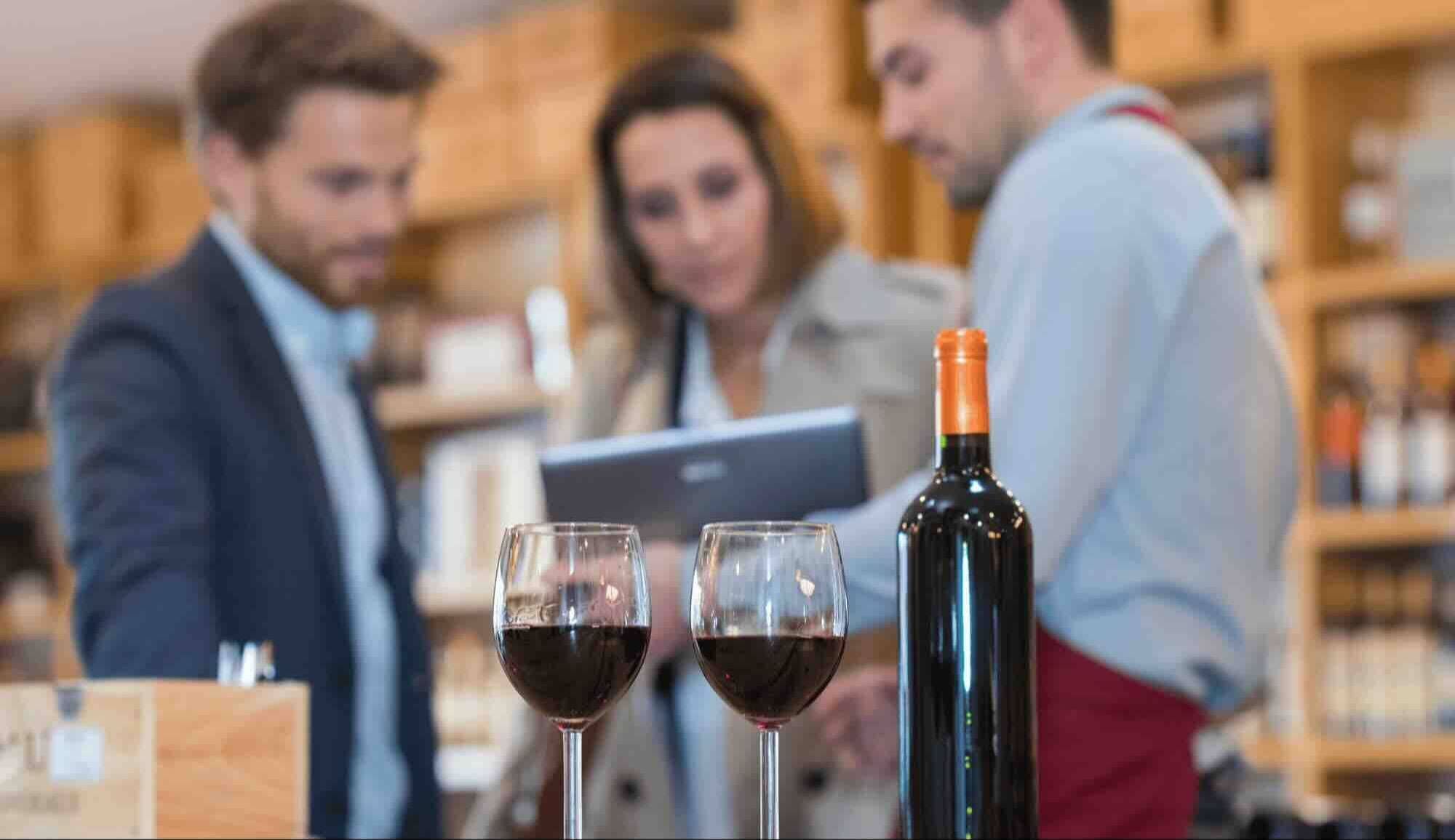 Medewerkers van een wijnhandel krijgen uitleg bij een fles wijn