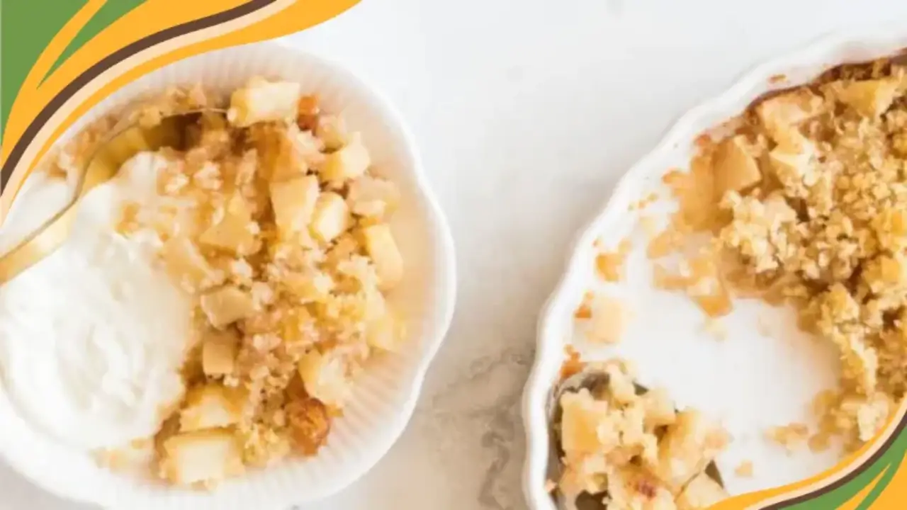 Delicious apple crumble with creamy yogurt in a white bowl on a marble surface, accompanied by a golden spoon.