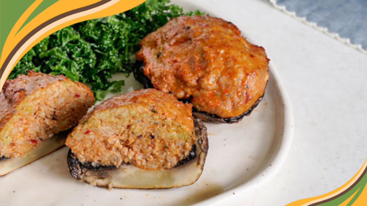 Stuffed portobello mushrooms with a savory meat filling served alongside a fresh kale salad on a white plate.