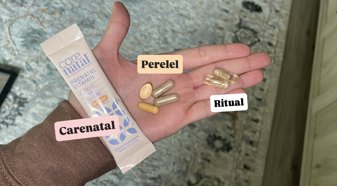 Dalia holding one CareNatal stick pack next to a day's worth of Perelel and Ritual capsules, each labeled