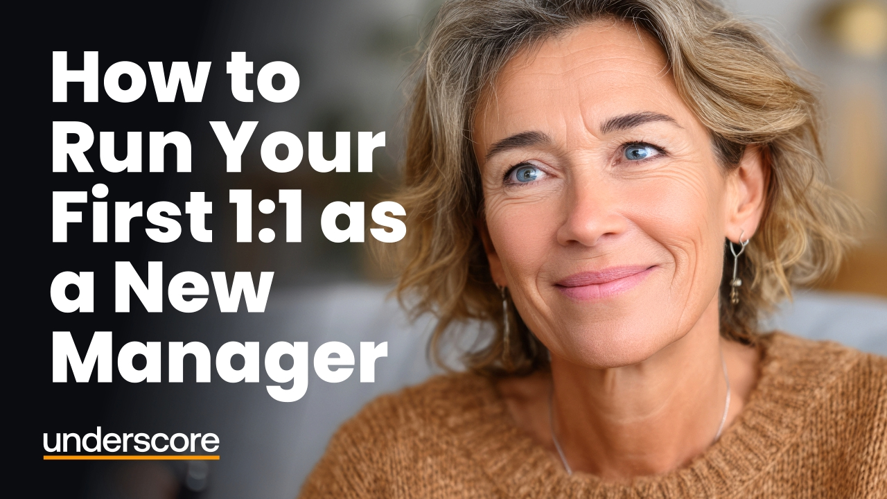 Close-up of a professional woman in a modern office setting with the text “How to Run Your First 1:1 as a New Manager” displayed alongside her.