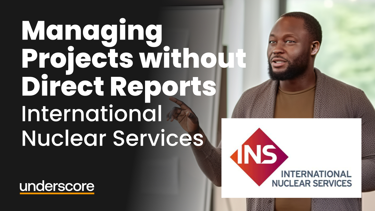 A man gestures while speaking during a presentation. The text reads “Managing Projects without Direct Reports – International Nuclear Services,” featuring the INS logo and the Underscore logo on a dark background.