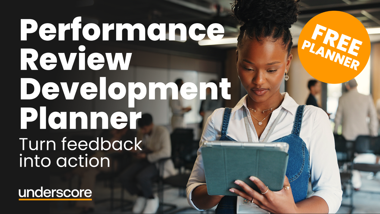 Professional reviewing performance feedback and development plans on a tablet in a modern office environment, representing employee development planning and training needs identification.