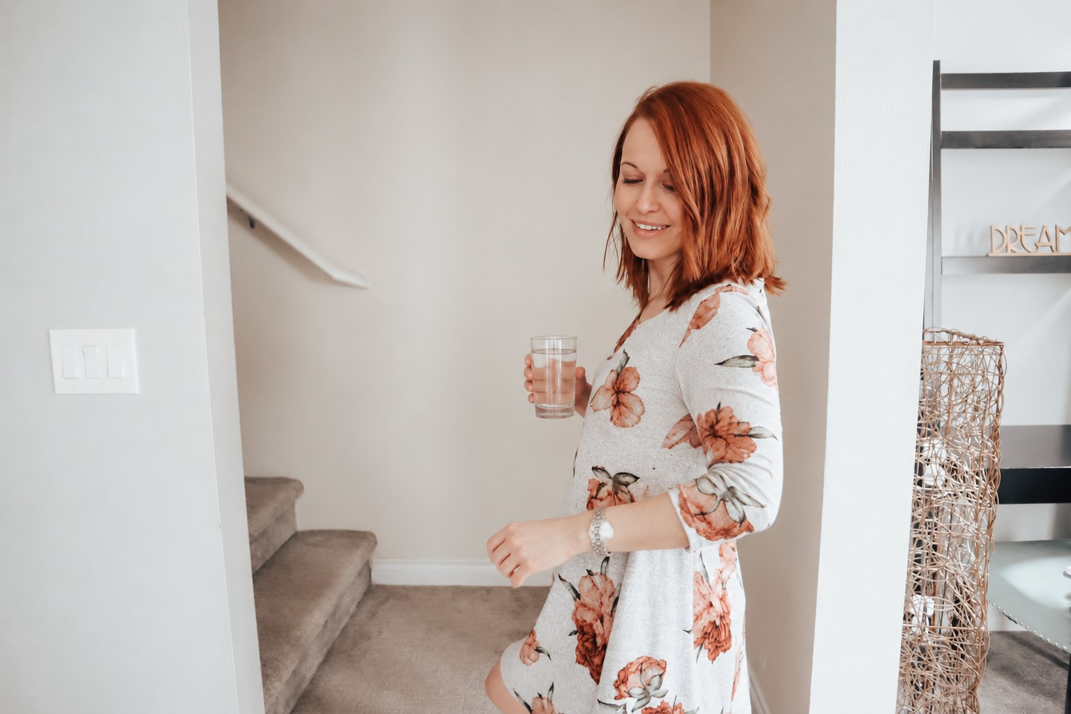 Woman with a glass of water heading for the stairs, using them as daily movement
