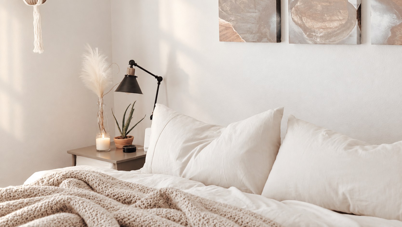 Freshly reset bedroom with a cozy throw, a lit candle and a plant