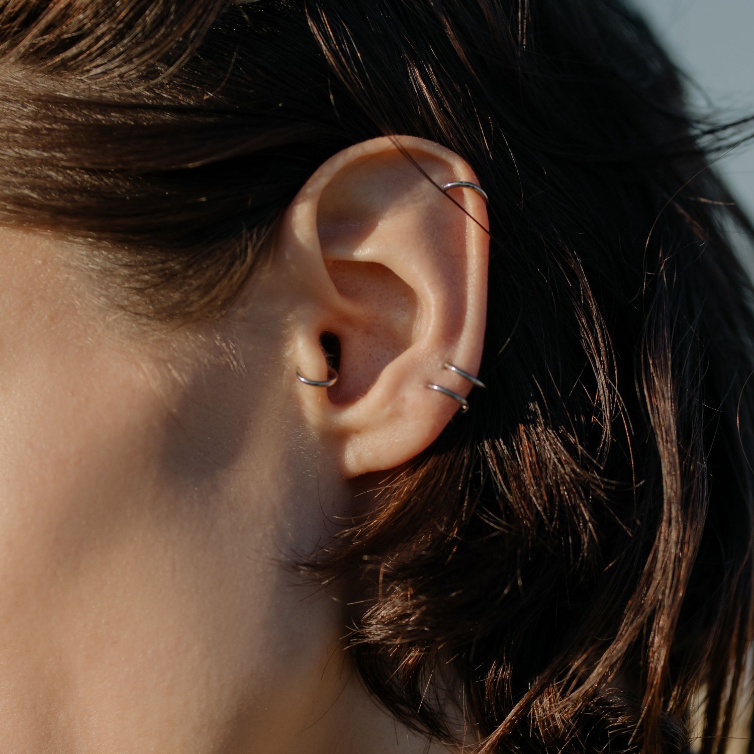 A curated ear stack with lobe, conch and helix piercings