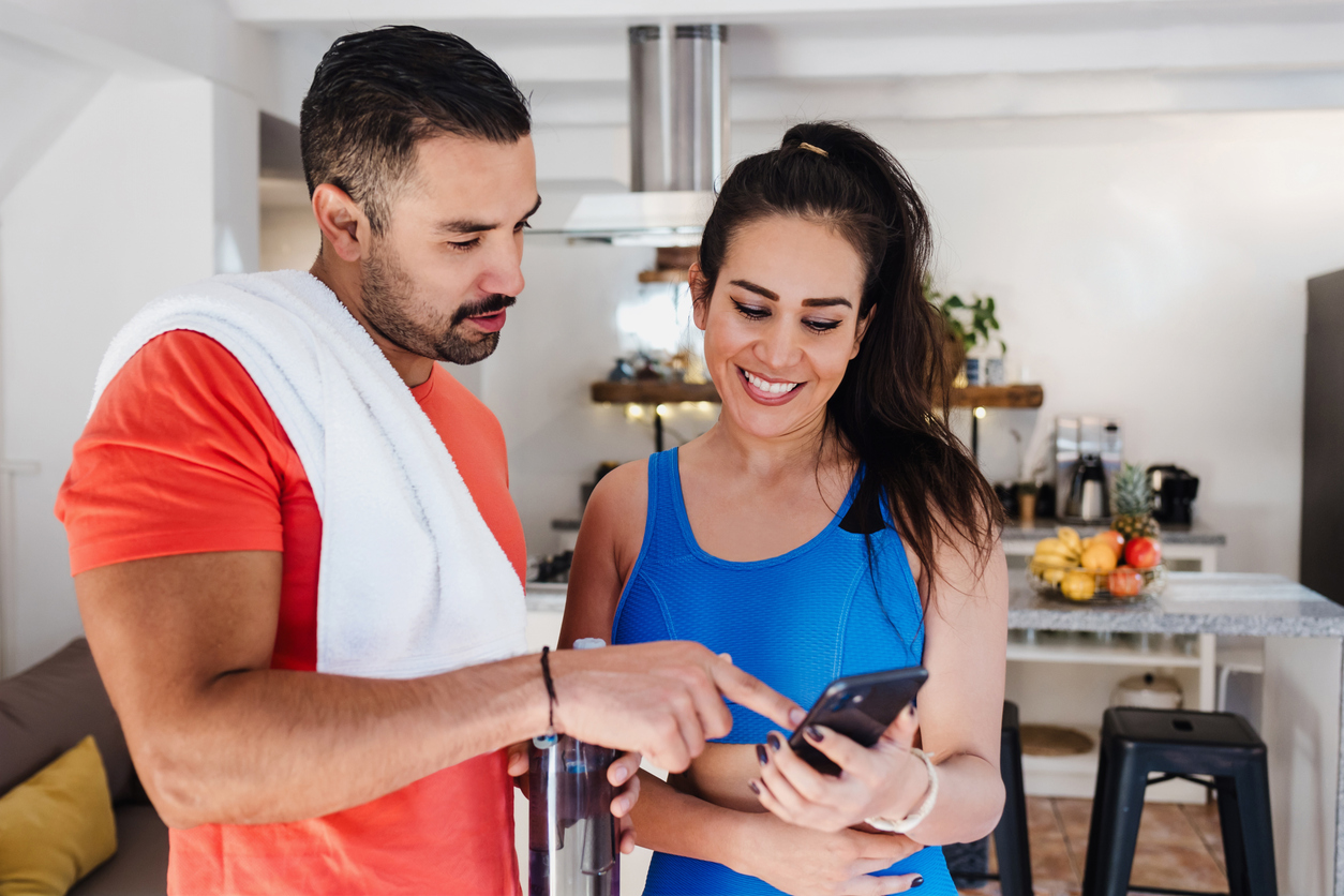 Active couple checking their insurance coverage for nutrition counseling on a phone