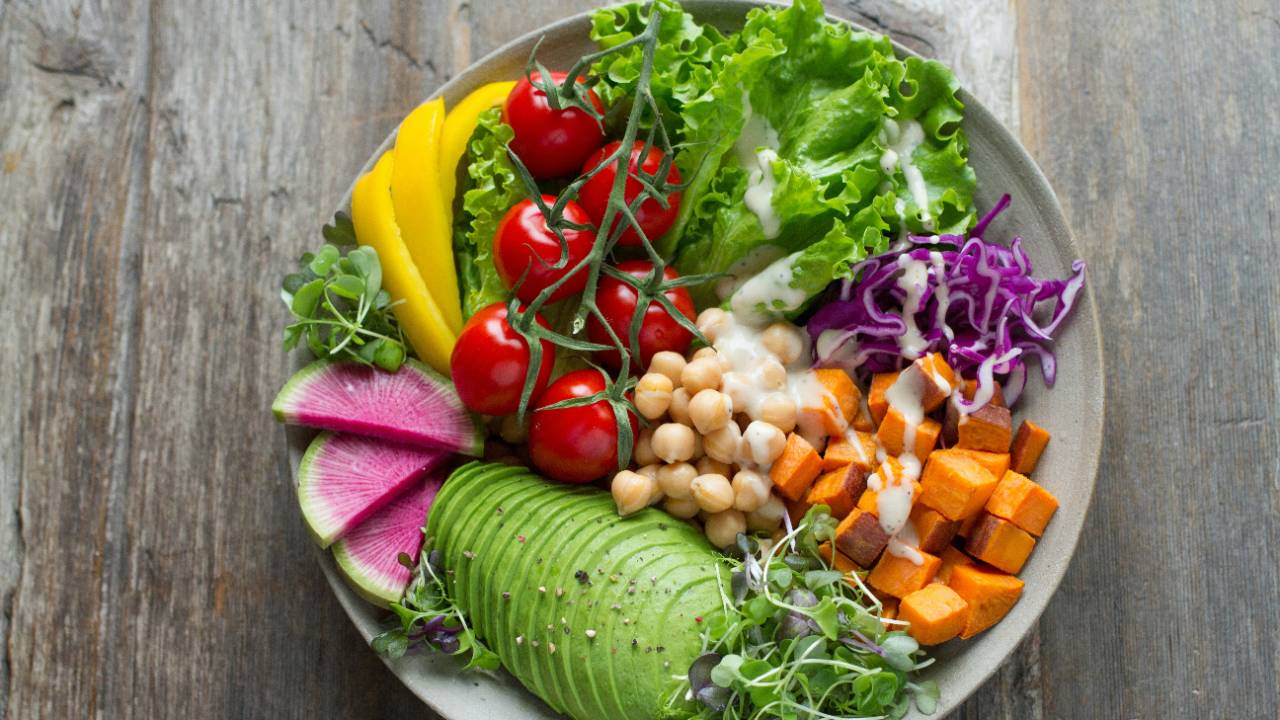 Plate with colorful, healthy foods 9avocado, tomatoes, lettuce, more)