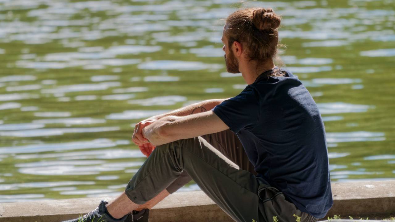 Man sitter vid vattnet och blickar ut