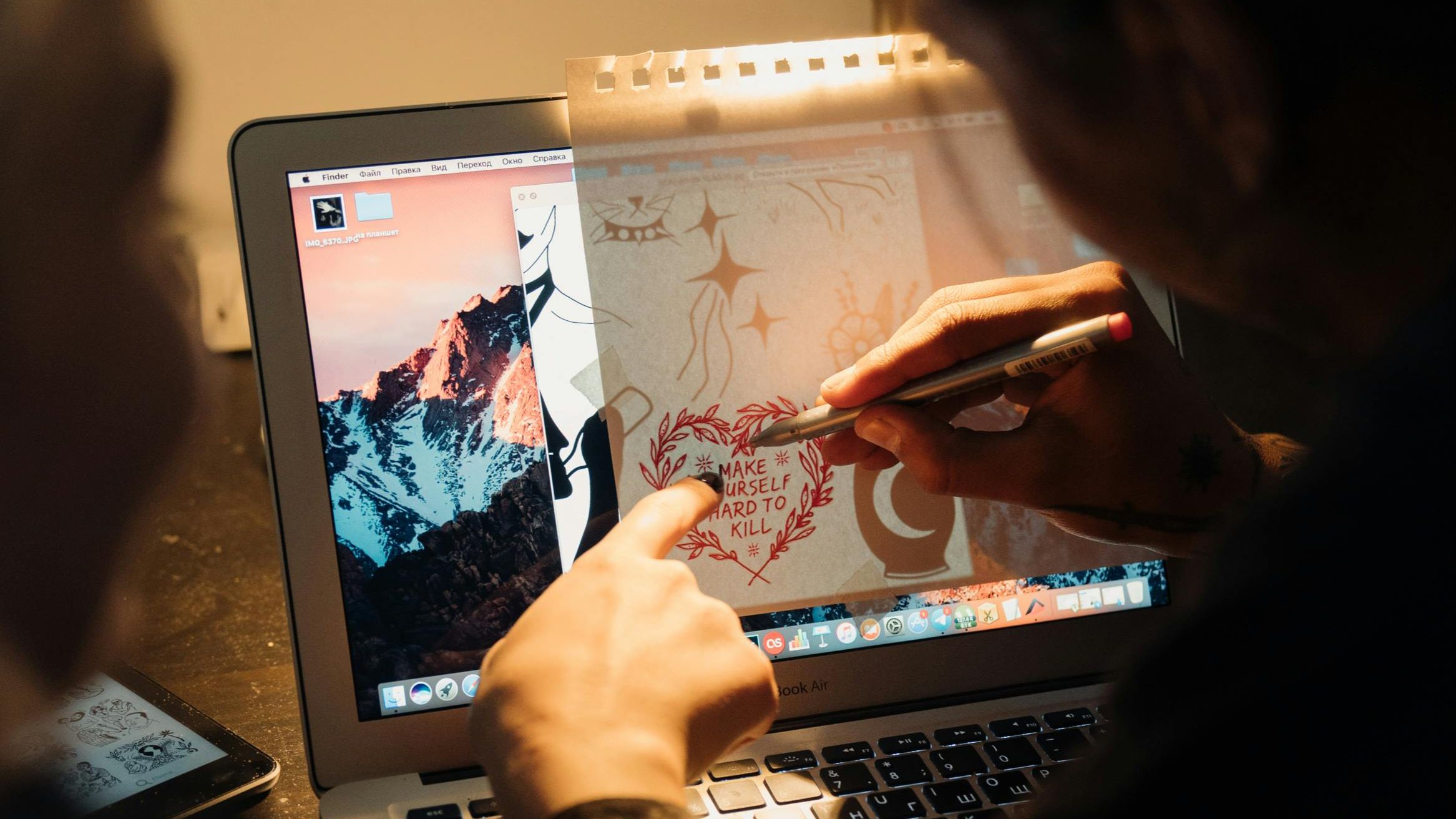 Designers collaborating around a desk with sketches, laptops, and design materials in a bright modern design studio