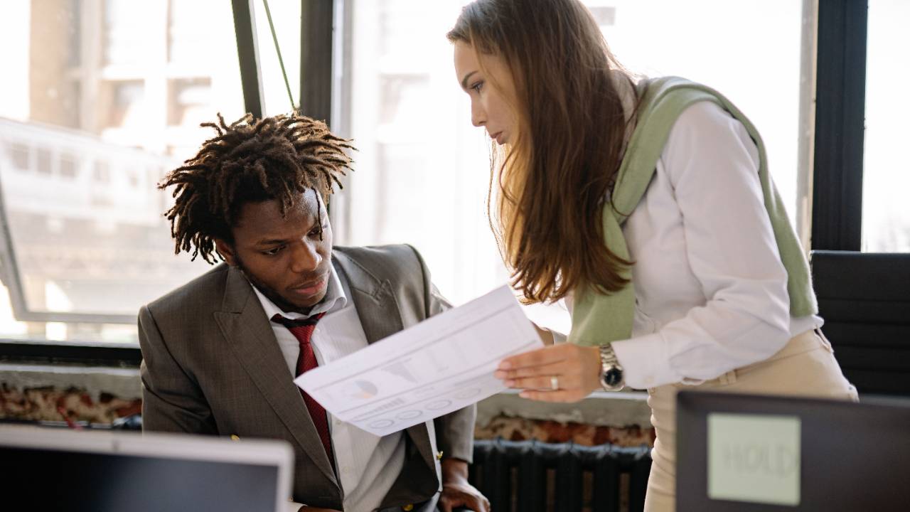 account manager and project manager reviewing a project plan together in an agency meeting room