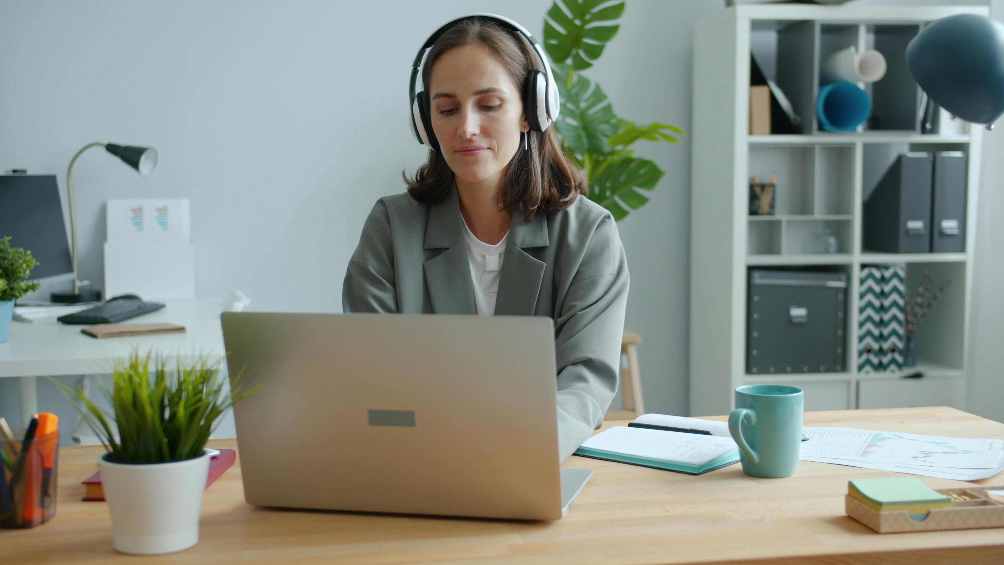 Career changer comparing online certification options on laptop with notebook and coffee at a desk in a bright home office