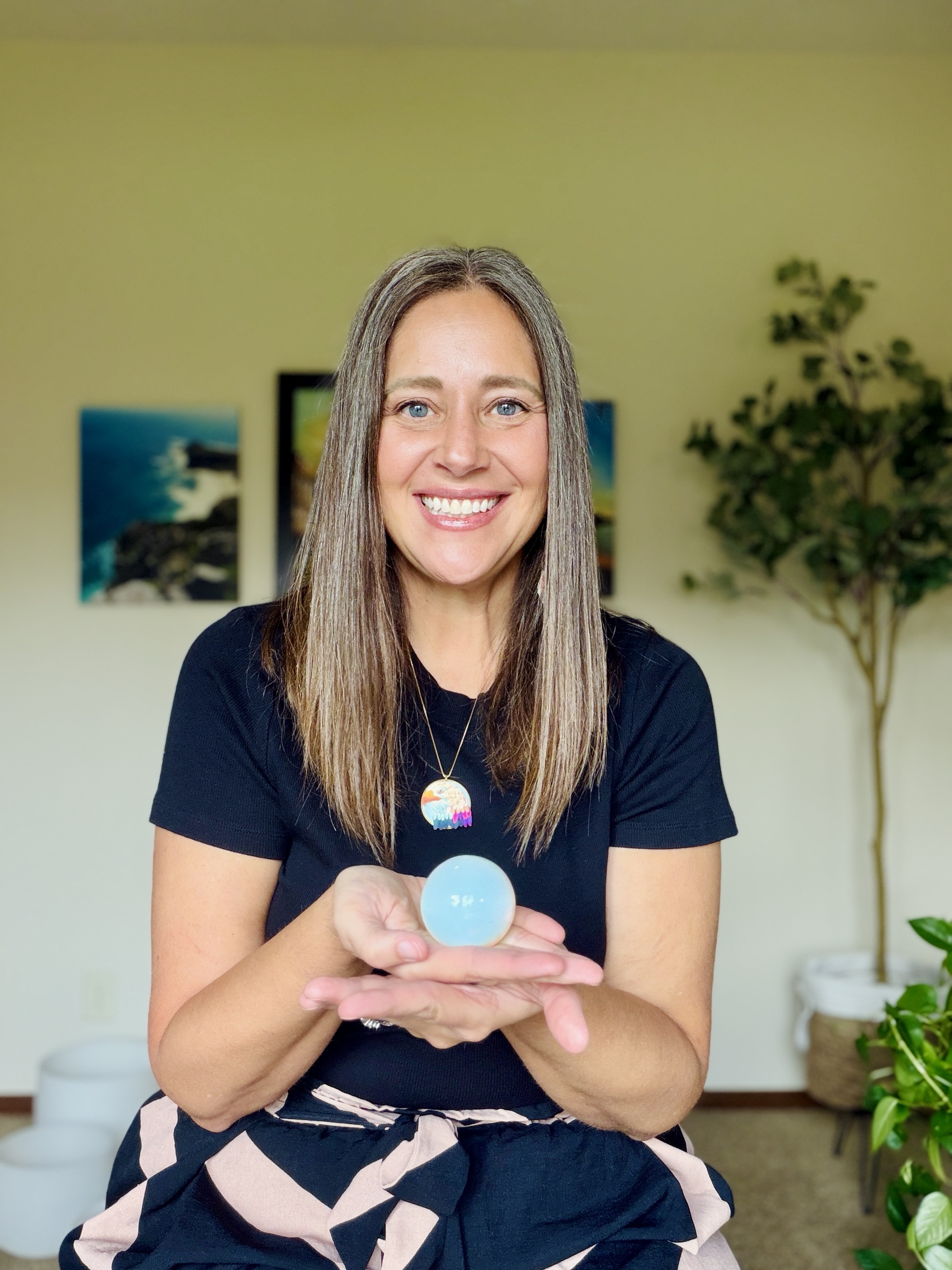 Kara Bunde-Dunn smiling and holding a crystal sphere