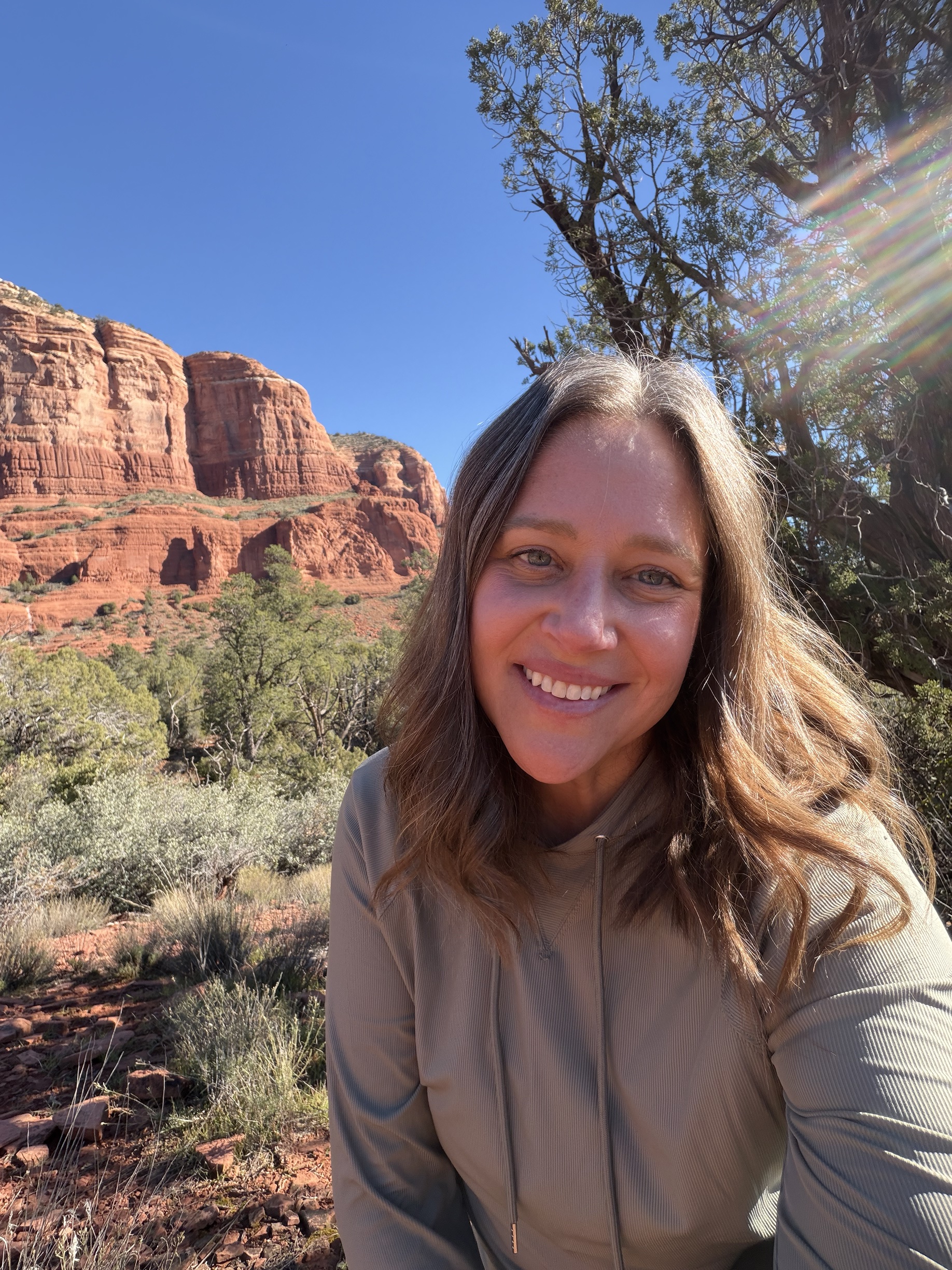Kara smiling in front of the red rocks of Sedona
