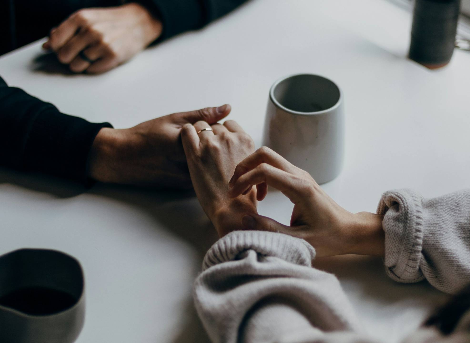 Two people holding hands in a supportive gesture