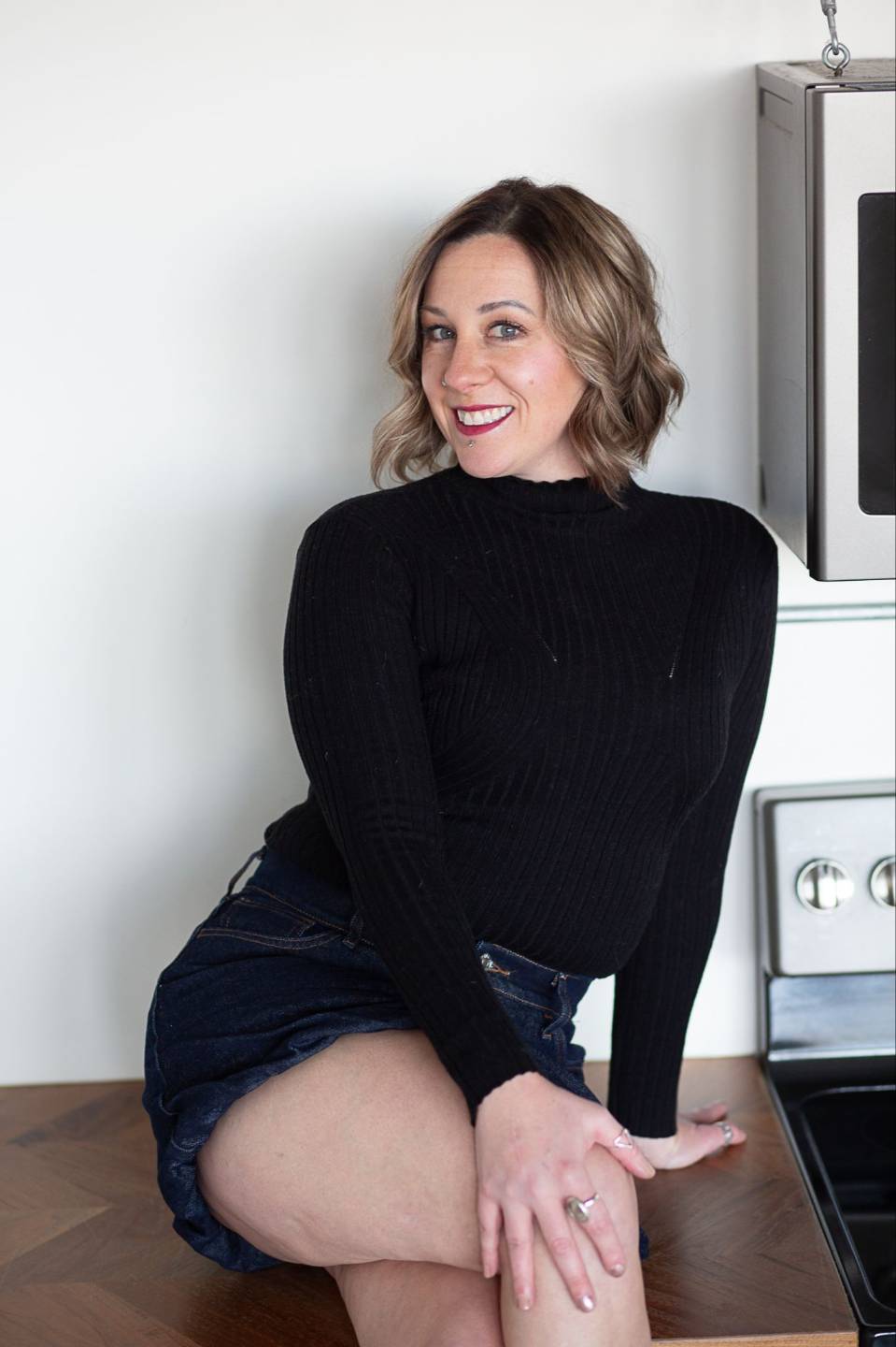 Chelsea smiling in a black sweater