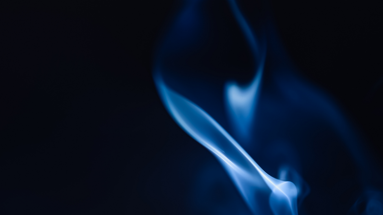 Abstract blue flame glowing against a dark background, representing Jacob Goettsche's Blue Flame metaphor for intensity developing structure, Ground, purpose, and useful direction.