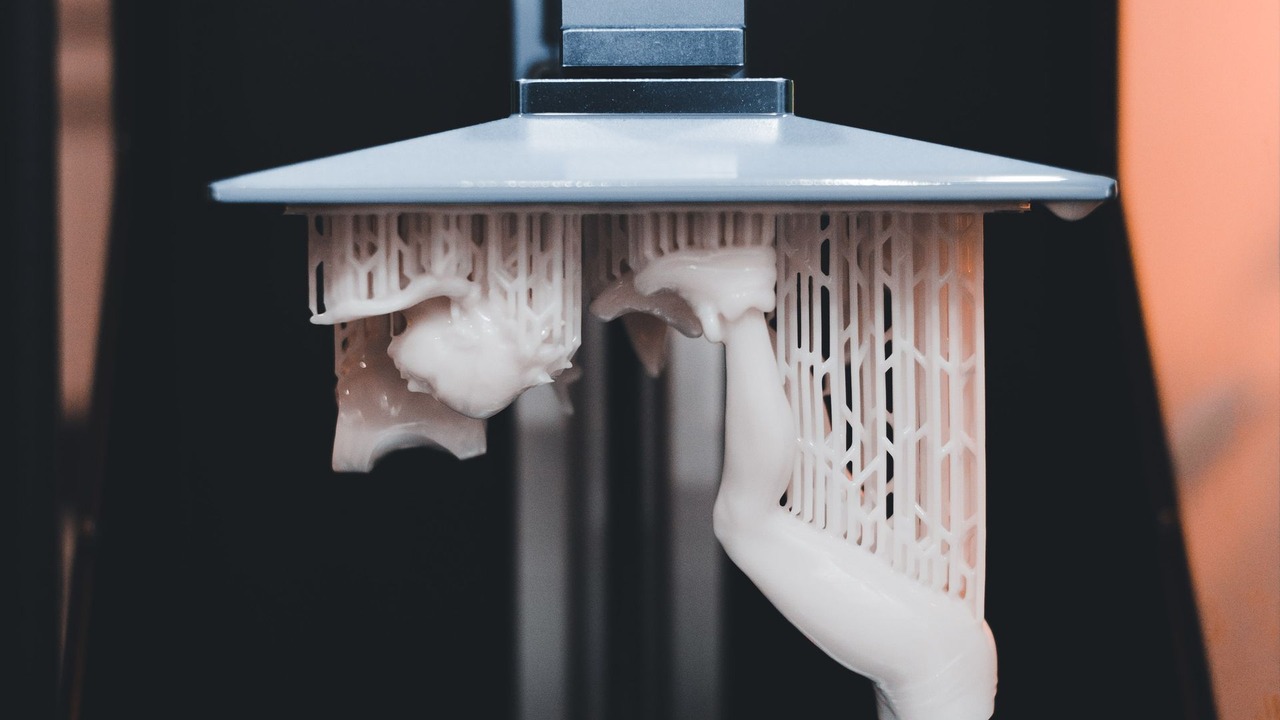 Detalle de una impresora 3D de resina durante la fabricación de una pieza.