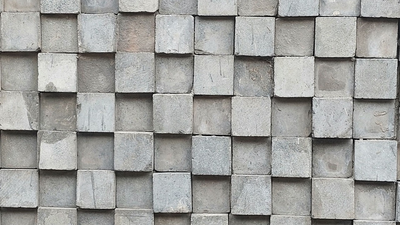 Primer plano de un muro de baldosas de piedra con un patrón geométrico repetido.