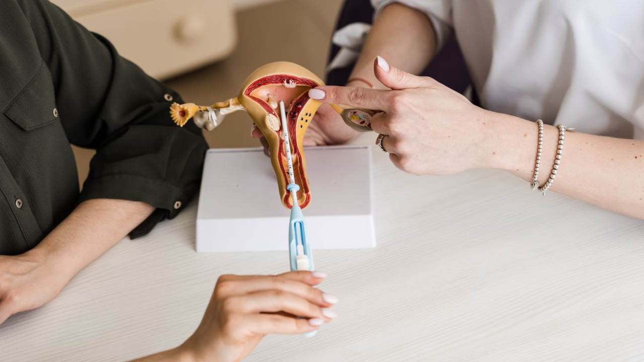 women's health practitioner showing IUD placement on a uterine model
