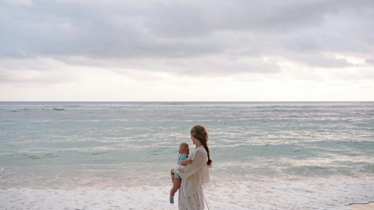 mother holding baby on a beach