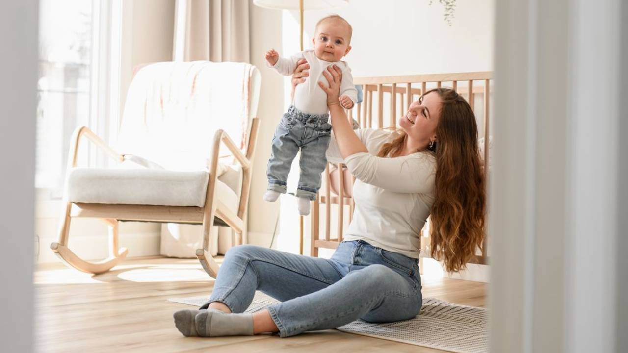 mom holding up baby in mirror