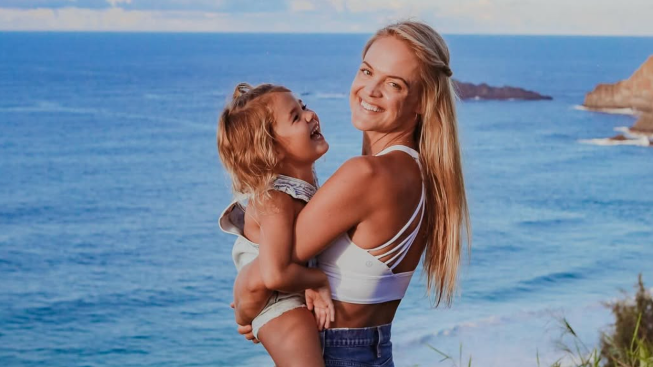 Dr. Angie holding daughter Maya by ocean