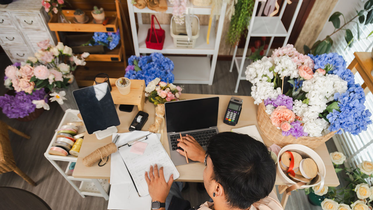 Flower-shop owner reviewing business figures at a table