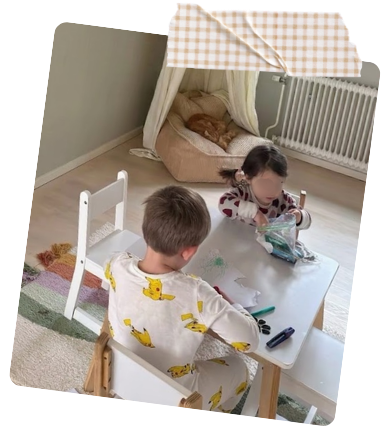 Two children doing a creative activity together at a table