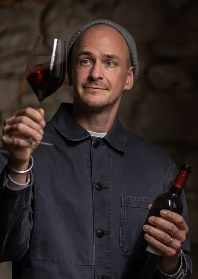 Konstantin Baum, Master of Wine, examining a glass of red wine