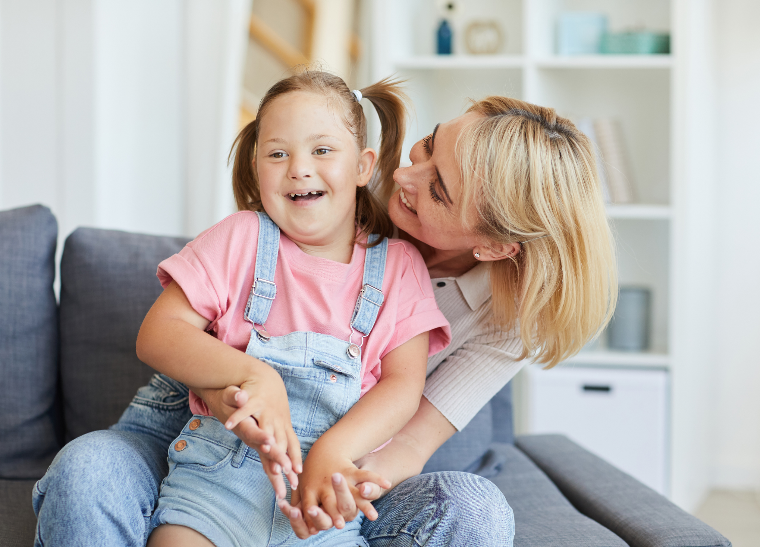 Mom and daughter laughing together on the couch