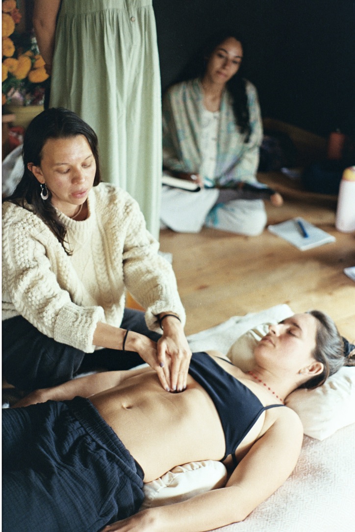 Aya Maria working on a participant’s abdomen while a student takes notes