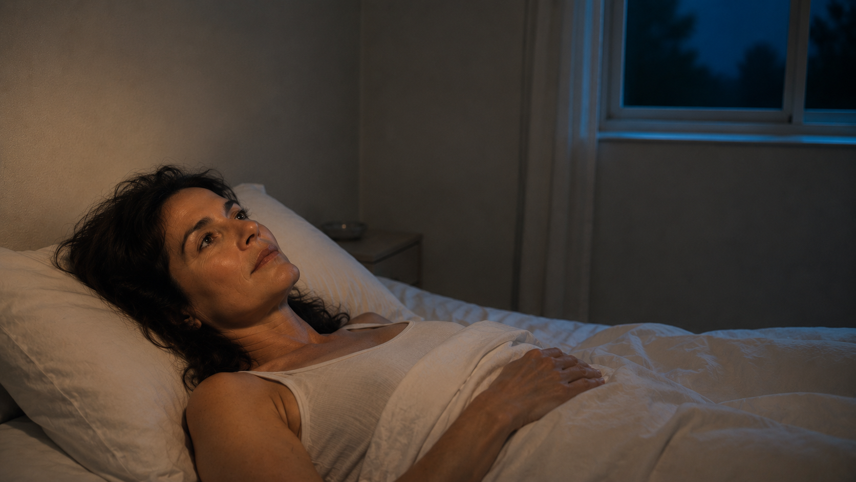 Donna sveglia di notte nel letto durante il momento dopo una vampata — articolo Koel Pilates sulle vampate