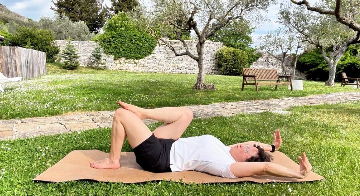 La respirazione diaframmatica è una bufala, il respiro che scende davvero Elena Visentin sdraiata sul tappetino in giardino, ginocchia piegate e braccia aperte, mentre lavora sulla respirazione