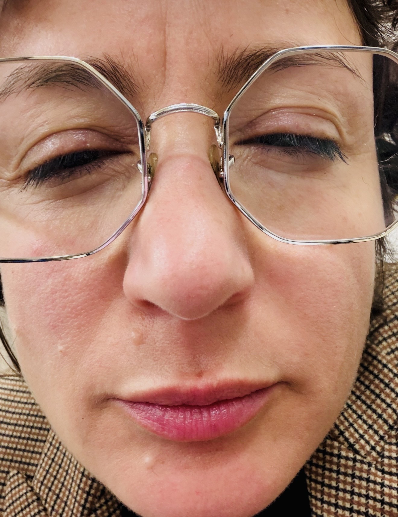 Elena Visentin in un selfie ravvicinato e scherzoso, occhiali e occhi chiusi, a commento della battuta sulla telecamera in casa