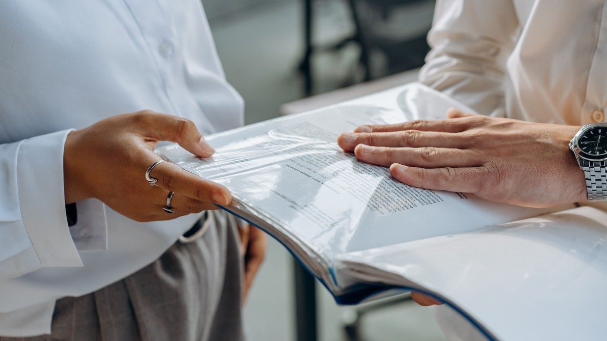 Hands reviewing a printed audit document