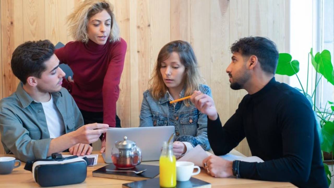 Colleagues discussing their work around a laptop