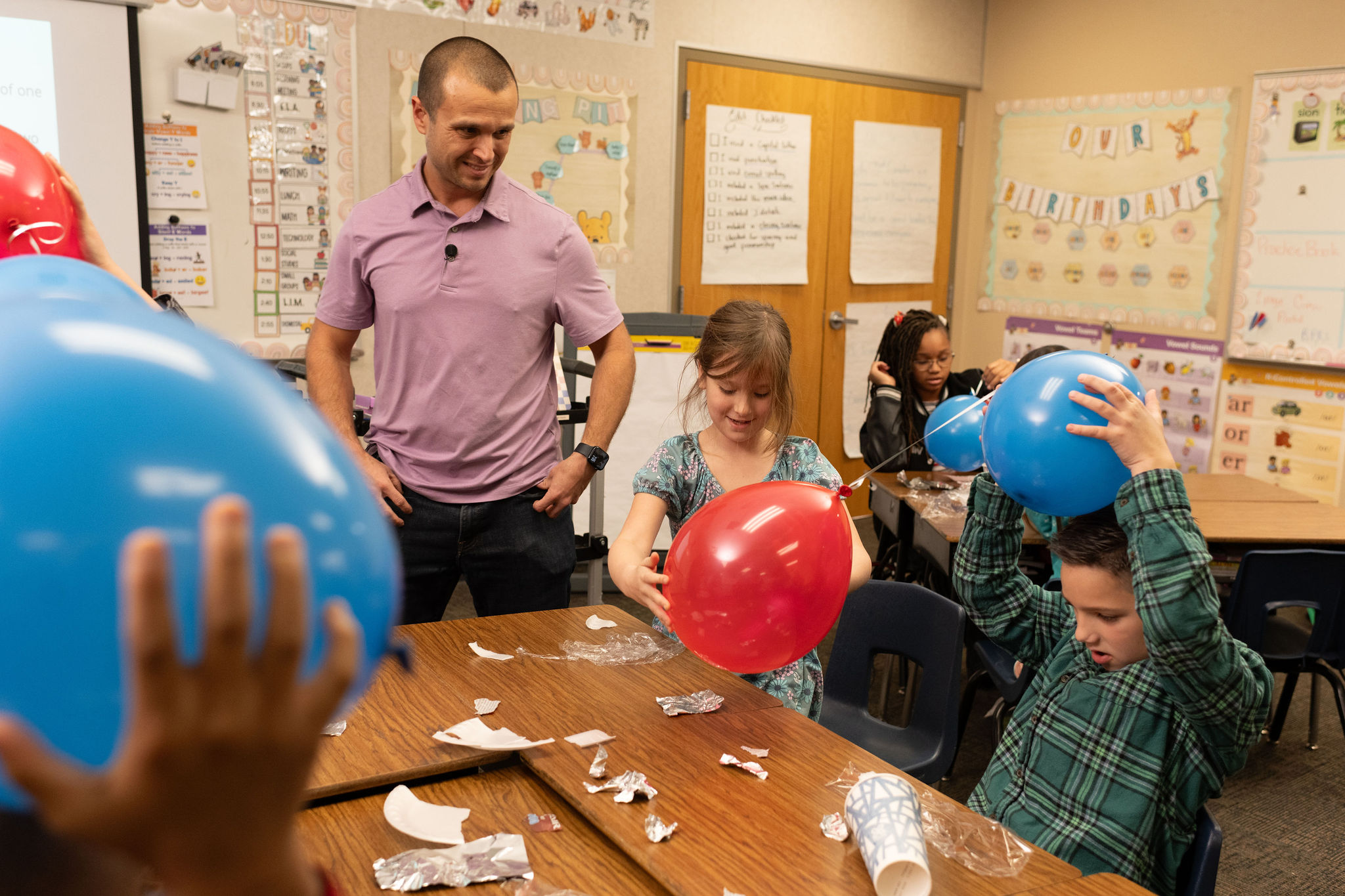 Teacher and students with balloons during a science lab