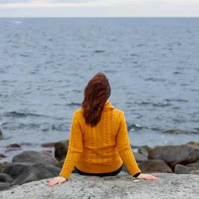 Woman-Sitting-By-The-Ocean-Practicing-Mindfulness-For-Calm-And-Emotional-Balance