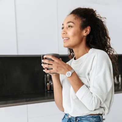Woman enjoying morning tea in kitchen for calm energy and wellness