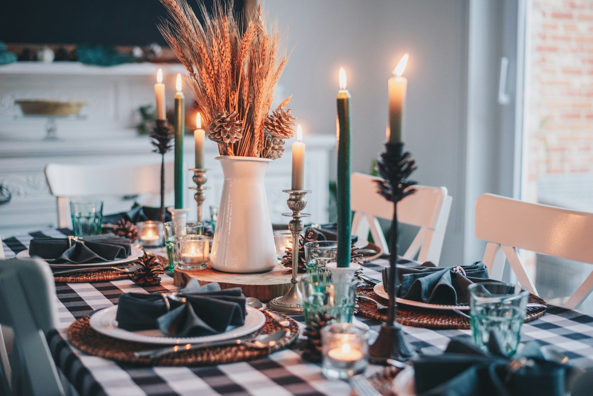 White candles and dried wheat on a table in soft light